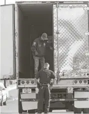  ?? Jerry Lara / San Antonio Express-News ?? Law enforcemen­t personnel survey the scene where nine immigrants died in a tractor-trailer at a Walmart in San Antonio.