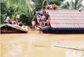  ?? ABC Laos News/Handout via
REUTERS ?? DITO KAMI! Nagakyatan sa bubungan ng kanilang mga bahay ang mga residente matapos gumuho ang Xepian-Xe Nam Noy hydropower dam, sa Attapeu province ng Laos, nitong Martes.