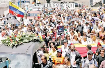  ??  ?? Mourners walk behind the hearse carrying Alban’s coffin during his funeral in Caracas,Venezuela. — Reuters photo