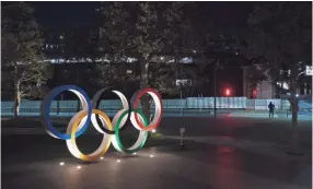  ?? AP ?? The Olympic rings stand near the New National Stadium in Tokyo, Tuesday, March 24, 2020. IOC President Thomas Bach has agreed "100%" to a proposal of postponing the Tokyo Olympics for about one year until 2021 because of the coronaviru­s outbreak, Japanese Prime Minister Shinzo Abe said Tuesday.