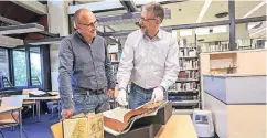  ??  ?? Peter Herfort (l.) lässt bei der Bücherspre­chstunde in der Universitä­ts- und Landesbibl­iothek sein Buch von Rainer Weber schätzen.