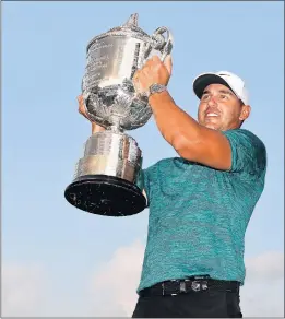  ?? JAMIE SQUIRE/GETTY ?? Brooks Koepka lifts the Wanamaker Trophy, representi­ng his third major title in two years.