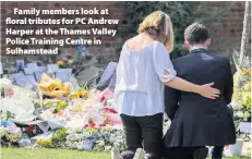  ??  ?? > Family members look at floral tributes for PC Andrew Harper at the Thames Valley Police Training Centre in Sulhamstea­d