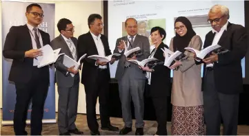  ?? — Bernama photo ?? Sharil Ridza Redzuan (centre), Khazanah Research Institute executive committee chairman Hisham Hamdan (third left) and others looking at the ‘School-To-Work Transition Of Young Malaysians’ report at Mercu UEM.