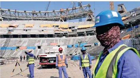  ?? FOTO: HASSAN AMMAR/AP ?? Bauarbeite­r arbeiten am Lusail-Stadion in Katar. Viele Arbeiter auf den WM-Baustellen kommen aus Nepal, Indien und Bangladesc­h.