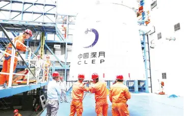  ??  ?? Employees loading the Queqiao (‘Magpie Bridge’) satellite at the Xichang launch centre.