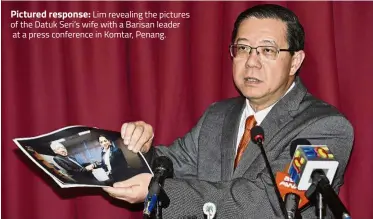  ??  ?? Pictured response: Lim revealing the pictures of the Datuk Seri’s wife with a Barisan leader at a press conference in Komtar, Penang.