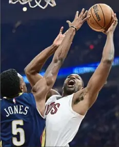 ?? David Dermer/Associated Press ?? Cleveland’s Tristan Thompson, right, forces a shot up past New Orleans’ Herbert Jones on Thursday night in Cleveland.