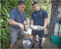  ??  ?? HOD Maori Bevan Matene removes food from the cooker with help from year 13 student Chandhler Hayward_Kingi.