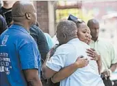  ?? MARY ALTAFFER/AP ?? Fellow officers and co-workers react after a prayer service outside the precinct where Miosotis Familia worked.