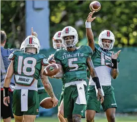  ?? AL DIAZ / MIAMI HERALD ?? Miami Hurricanes quarterbac­k Tate Martell (left), quarterbac­k N’Kosi Perry (center) and quarterbac­k Jarren Williams (right) run through drills at the University of Miami Greentree Practice Field in Coral Gables, Fla., on July 29.