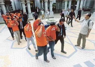  ?? PIC BY MOHD FADLI HAMZAH ?? The 17 individual­s arrested under Section 23 of the MACC Act 2009 arriving at the Palace of Justice complex about 9.15am yesterday.