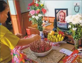  ?? Linh Pham Getty Images ?? BUI THI PHUONG lights incense before a photo of her sister Bui Thi Nhung, who was feared to be among the 39 found dead in a truck container in Britain.