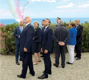  ??  ?? Da sinistra Tusk, Trump, May, Abe, Macron, Juncker (di spalle), Trudeau, Merkel e Gentiloni guardano le Frecce Tricolori a Taormina