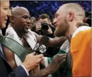  ?? ISAAC BREKKEN - THE ASSOCIATED PRESS ?? Floyd Mayweather Jr., left, speaks with Conor McGregor after a super welterweig­ht boxing match Saturday in Las Vegas.