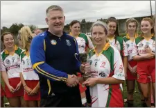  ??  ?? Wicklow Camogie Chairman Ivor Lehane presents Elisha Ryan with the Intermedia­te league cup.