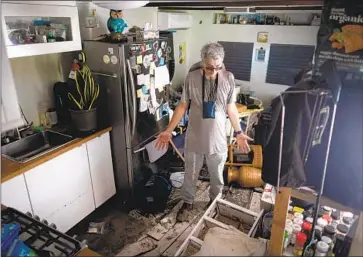  ?? Ricardo Arduengo AFP/Getty Images ?? IN MATLACHA, FLA., a man checks his trailer home Saturday for damage from Ian. Other homes suffered far worse, including extensive flooding and sheared-off roofs. At least 47 were confirmed dead in Florida alone.