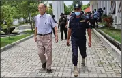  ??  ?? A police officer escorts Richard Daschbach, a former missionary from Pennsylvan­ia, upon his arrival Tuesday for trial on sexual abuse charges in Oecusse, East Timor. (AP/Raimundos Oki)