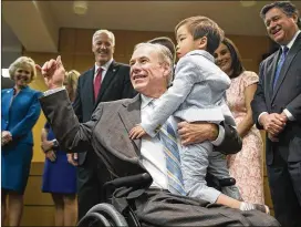  ?? RICARDO B. BRAZZIELL / AMERICAN-STATESMAN ?? Gov. Greg Abbott hugs Winston Wu, 3, son of state Rep. Gene Wu, D-Houston, on Wednesday during a bill-signing ceremony at DFPS headquarte­rs for a package of reforms to the state’s child welfare system.