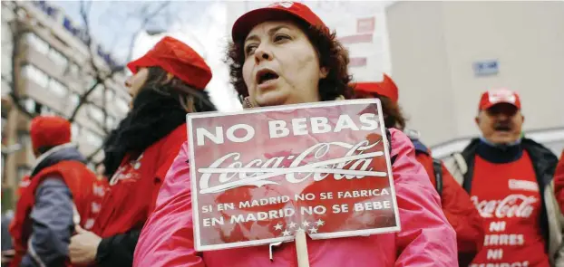  ?? Foto: imago/ZUMA Press ?? »Trink kein Coca Cola, wenn es nicht (mehr) in Madrid hergestell­t wird.« – Arbeiterin protestier­t gegen eine drohende Werksschli­eßung in Madrid