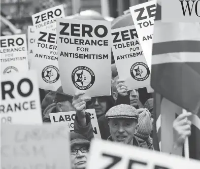  ?? TOLGA AKMEN / AFP / GETTY IMAGES ?? Protesters hold up signs and flags as they gather for a rally organized by the Campaign Against Anti-semitism outside the head office of Britain’s Labour Party in London earlier this year. British police announced on Friday they are investigat­ing alleged anti-semitic hate crimes within the party.