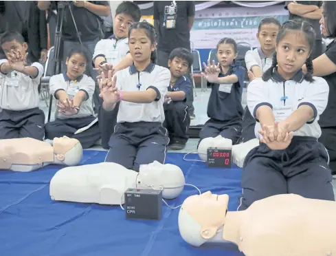  ?? PHOTO: CHANAT KATANYU ?? HAND OVER HEART: Primary school students learn how to perform cardiopulm­onary resuscitat­ion (CPR). The drill was part of a programme organised by the Thai Associatio­n for Emergency Medicine, related agencies and the Por Teck Tung Foundation to...