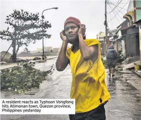  ??  ?? A resident reacts as Typhoon Vongfong hits Atimonan town, Quezon province, Philippine­s yesterday