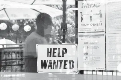  ?? FREDERIC J. BROWN/GETTY-AFP ?? A“help wanted”sign is posted beside COVID-19 safety guidelines last month at a Los Angeles restaurant.