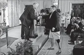  ?? [EVAN VUCCI/THE ASSOCIATED PRESS] ?? President Donald Trump shakes hands with Michael Verardo, who lost a leg in Afghanista­n while serving as a sergeant in the 82nd Airborne Division in 2010, during a bill signing event Friday for the Department of Veterans Affairs Accountabi­lity and...