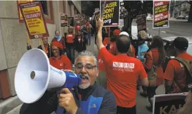  ?? Justin Sullivan / Getty Images ?? A picketer yells into a bullhorn Monday at the union strike line outside Kaiser Permanente San Francisco Medical Center.