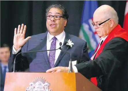  ?? DARREN MAKOWICHUK ?? Calgary mayor Naheed Nenshi is sworn in by Associate Chief Justice John D. Rooke on Monday. Nenshi told reporters Monday he wants to extend the $45-million tax relief program for another year and is working with city administra­tors to identify how...