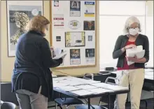  ?? Lori Van Buren / Times Union ?? Rensselaer County contact tracers Beverly Falquez, left, and Terri Jackson sort out forms Friday at the Rensselaer County Office Building in Troy as they work on tracking people down who have been exposed to COVID-19.