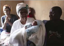  ?? TSVANGIRAY­I MUKWAZHI — THE ASSOCIATED PRESS ?? Esther Zinyoro Gwena holds one of the babies she has just delivered in her tiny apartment in the poor suburb of Mbare in Harare, Zimbabwe, on Saturday.