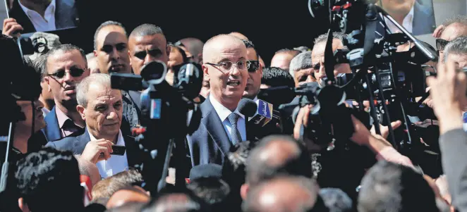  ??  ?? Palestinia­n Prime Minister Rami Hamdallah (C) addresses the media upon his arrival in the West Bank town of Ramallah following his return from the Gaza Strip where an explosion targeted his convoy, March 13.