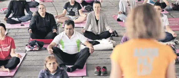  ??  ?? Adultos mayores y jóvenes asisten los domingos a relajarse y mostrar su destreza física en las clases de yoga que se imparten como parte del Paseo Dominical.