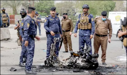 ??  ?? عناصر أمن في موقع انفجار الدراجة النارية في بغداد أمس