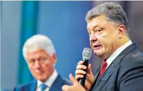  ??  ?? Former President Bill Clinton, left, listens as Petro Poroshenko, the president of Ukraine, speaks at the Clinton Global Initiative on Sunday in New York.