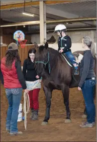  ?? NEWS PHOTO PEGGY REVELL ?? Dritan Mack sits atop Irish Monday at Forsyth Ranch, as part of his hippothera­py session with Andrea Bath, Ruth Isaac and Ellie Wilding.