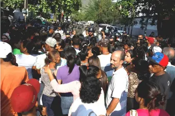  ??  ?? Relatives of inmates at the General Command of the Carabobo Police wait outside the prison in Valencia, Venezuela. — Reuters photo