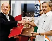  ??  ?? Defence Minister Manohar Parrikar and his French counterpar­t Jean Yves Le Drian shake hands after signing the deal on Friday.