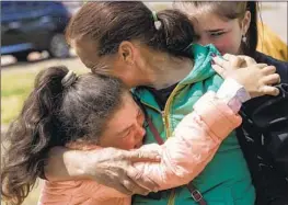  ?? Evgeniy Maloletka Associated Press ?? A GIRL hugs her mother after evacuating from Vovchansk,Ukraine, on Sunday. Thousands more in the country have f led Russia’s renewed ground offensive.