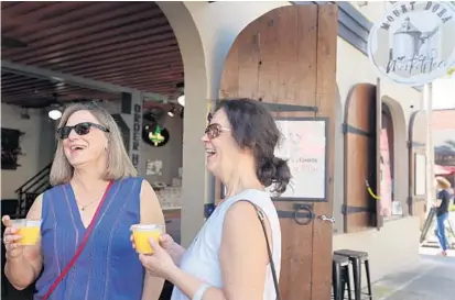  ?? RICARDO RAMIREZ BUXEDA/ORLANDO SENTINEL ?? Kathy Kohl, left, and Debbie Smith enjoy mimosas March 3 outside Mount Dora Marketplac­e.