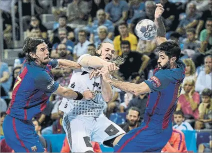  ?? FOTO: PERE PUNTÍ ?? Viran Morros y Raúl Entrerríos tratan de frenar a Lukas Nilsson en un Barça-Kiel de la temporada pasada