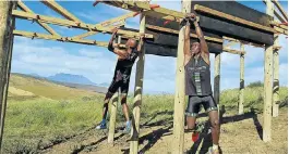  ??  ?? HANGING IN: Hlelani Radebe, left, and Dumisani Shabalala swing on one of the obstacles that form part of the races. It’s tough going, but the view of Table Mountain is good