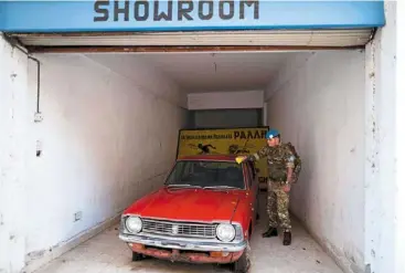  ?? afp ?? sapper sam proctor from the British army’s 71 engineer regiment wiping an abandoned car while patrolling along the buffer zone. —