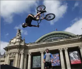  ?? THIBAULT CAMUS, THE ASSOCIATED PRESS ?? Belgian biker Kenneth Tancre performs outside the Grand Palais museum while French trampolini­st Allan Morante performs at the Petit Palais museum as Paris aims to boost its bid for the 2024 Olympics by turning some of its world-famous landmarks over to...