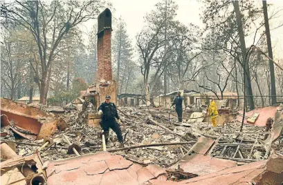  ?? JOSH EDELSON AFP/GETTY IMAGES ?? Alameda County Sheriff coroner officers search for human remains at a burned residence in Paradise, Calif.