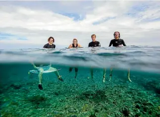  ?? DEREK MORRISON/BOX OF LIGHT ?? Jonas Tawharu slots into a tube at Fiji’s famous Cloudbreak during the Surfing New Zealand high-performanc­e camp, left, and, second from left, hanging out with fellow Kiwis Elliott Brown, Caleb Cutmore and Kaya Home .