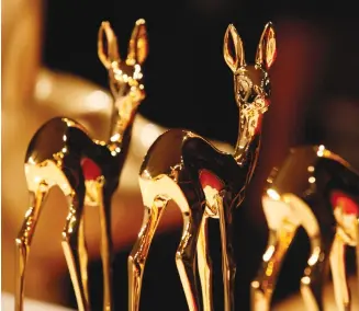  ?? (Wolfgang Rattay/Reuters) ?? THREE BAMBI Award gold-plated statuettes of a roe deer fawn at the award ceremony in Germany. r .*3*". ,"5&4 -0$,