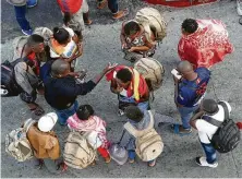  ?? Gregory Bull / Associated Press ?? People wait to apply for U.S. asylum along the border in Tijuana. A new U.S. rule says migrants who pass through another country on their way to the U.S. are ineligible for asylum. Critics say that violates internatio­nal and domestic law.